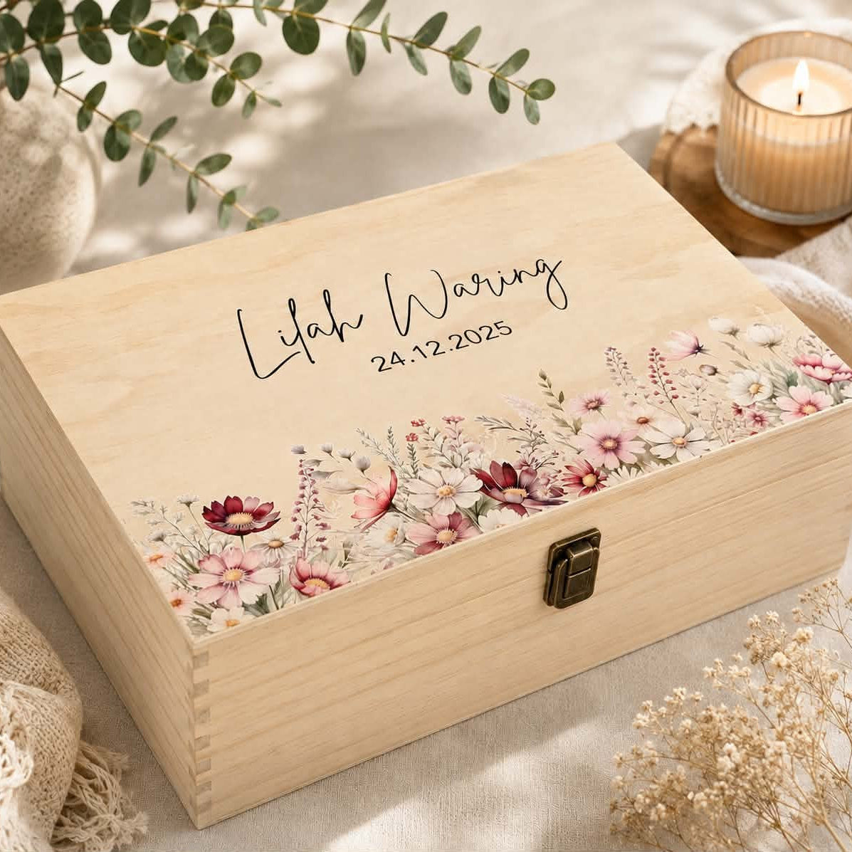 A personalized wooden keepsake box with a floral print along the bottom edge, featuring the engraved text 'Lilah Warring' and the date '24.12.